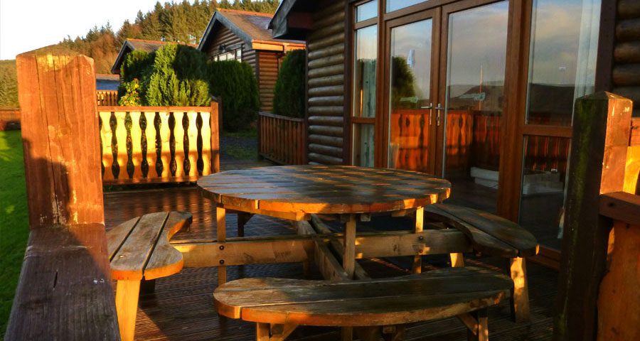 Log Cabins outside porch, Log Cabin Accomodation with Adventure Wales